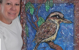 Woman poses with artwork of a Kookaburra