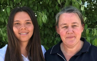 Two women smiling at the camera, one of them is a young Wiradjuri woman.